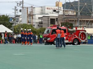 第70回大阪府消防大会の消防操法訓練に出場する消防団員と消防車